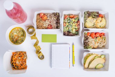 Sağlıklı beslenme planı. Taze günlük yemek teslim. Bir restoran gıda, sebze, et ve meyve folyo kutularında, detoks su, kartvizit, not defteri ve kalem beyaz arka plan üzerinde.