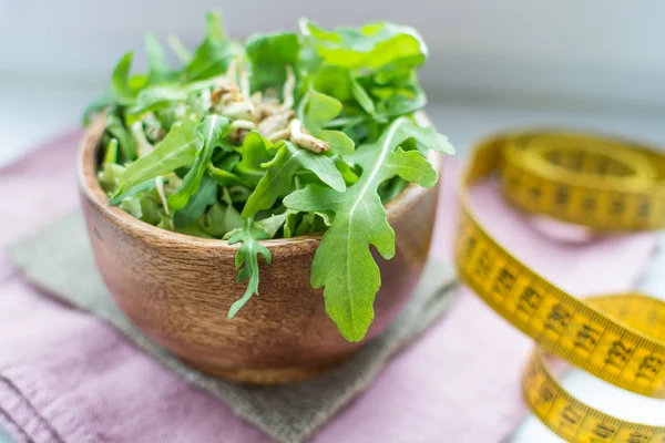 Roka Salatası ile ahşap bir kase ve bir ölçüm bandı tohum filizlenir. bir yumuşak odak portre