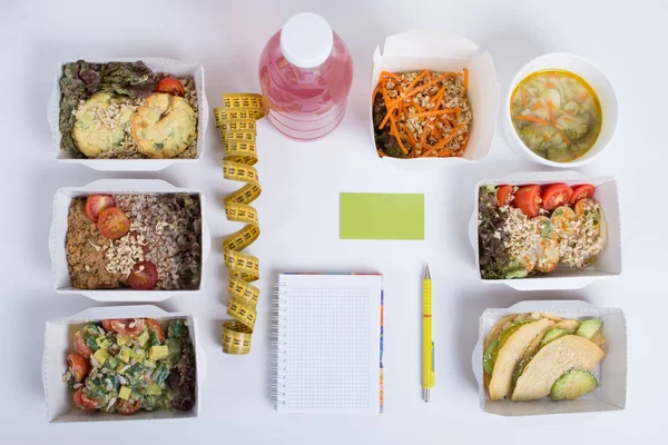 Sağlıklı beslenme planı. Taze günlük yemek teslim. Bir restoran gıda, sebze, et ve meyve folyo kutularında, detoks su, kartvizit, not defteri ve kalem beyaz arka plan üzerinde.