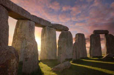 Stonehenge 'deki taş çemberinin içinde sabah güneşi kemerlerin arasından ışıldıyor.