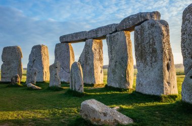 Stonehenge 'deki taş çemberinin içinde sabah güneşi kemerlerin arasından ışıldıyor.