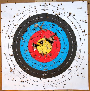 A well used target of concentric circles shot up with many holes clipart
