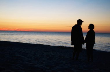 Sunset Beach, el ele tutuşarak Çift