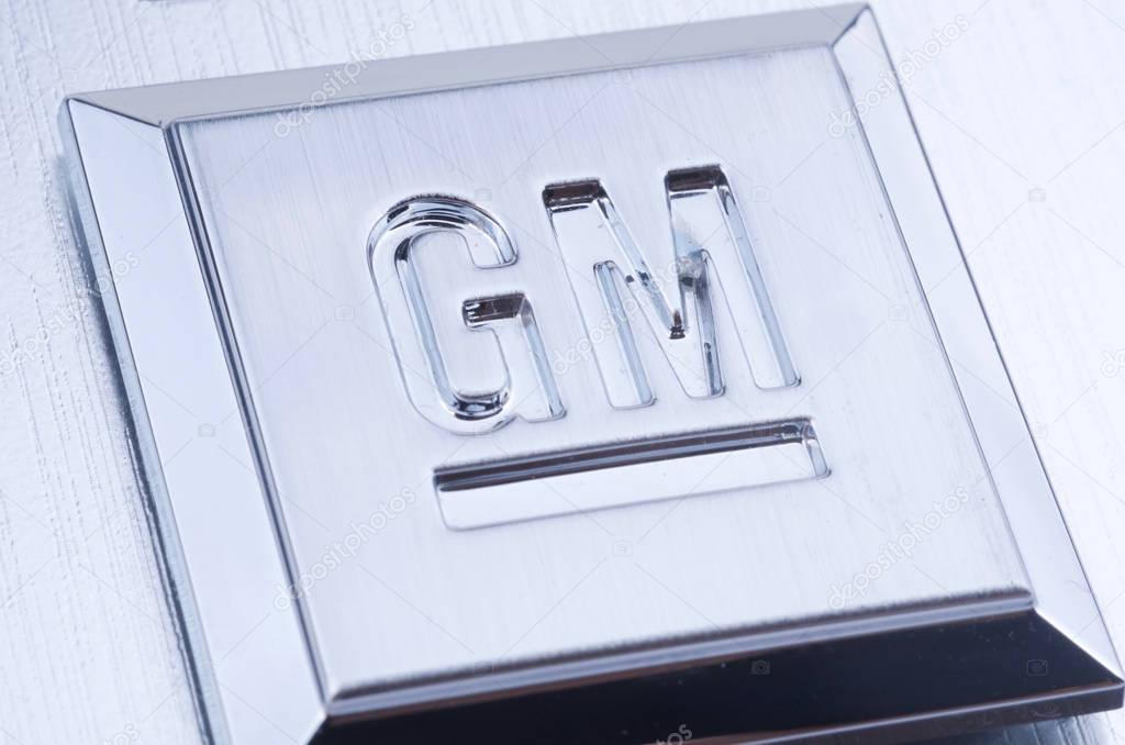 Close up shot of GM logo stamped into a square of brushed metal.