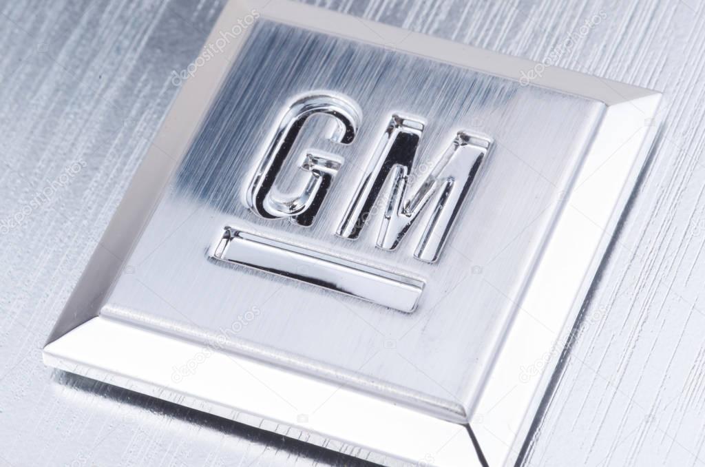 Close up shot of GM logo stamped into a square of brushed metal.