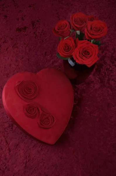 ハート型のチョコレートボックス 赤い砕いたベルベットの背景と白のレースランナーにバラの束とバレンタインシーン — ストック写真