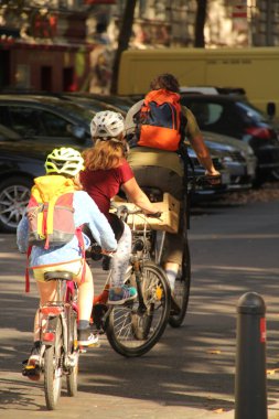 Berlin 'in bir caddesinde bisiklet süren bir motorcu.