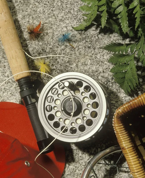 Arrangement of Fly Fishing Equipment, Fishing Rod, Red Cap, and Reel.