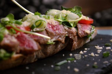 Biftek, soğan ve otlu kızarmış bruschetta.