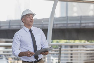 İş adamları ve mühendisler anlaşma belgelerini tutuyorlar..