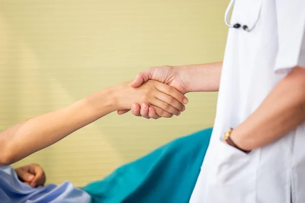 病院で患者を治療する手を握る医師,健康管理の概念. — ストック写真
