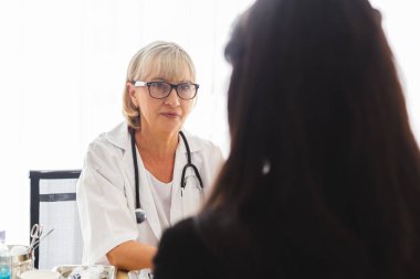 Kıdemli kadın doktor ve hasta tıbbi bilgi ve teşhisi, hastanede tedavi.