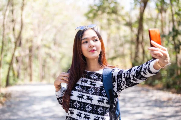 Щаслива жінка Селфі фотографується зі смартфонами, що подорожують у лісі . — стокове фото
