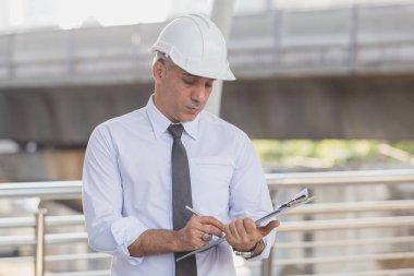 İş adamları ve mühendisler anlaşma belgelerini tutuyorlar..