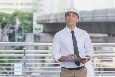 İş adamları ve mühendisler anlaşma belgelerini tutuyorlar..