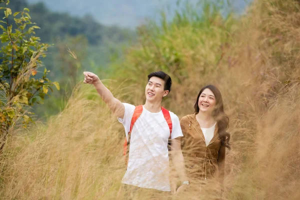 Азіатська пара подорожує по золотому лугу. красивий чоловік і жінка прекрасний, щастя . — стокове фото