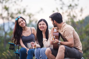 Erkek ve iki kadın. Üç kişi birlikte mutlu. Ormanda piknik yapıyorlar.,