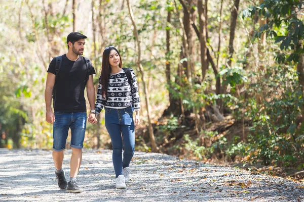 american man and asian women couple adventure travel backpack hiking, Happy couple walking in forest.