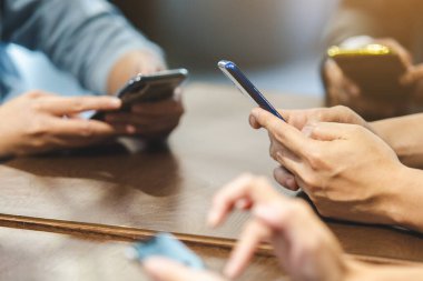 Ofisteki masada akıllı telefonları kullanarak elinizi kapatın. iş çevrimiçi kavramı.