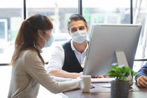 会議室企画で話す衛生マスクの予防管理者を身に着けているビジネスマン — ストック写真