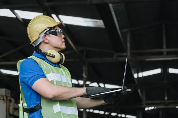 공장에서 노트북 검사기로 작업하고 안전모와 헬멧을 — 스톡 사진