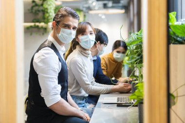 Tıbbi maske takan iş adamı ve kadın havada toz ve virüsü engelliyor.