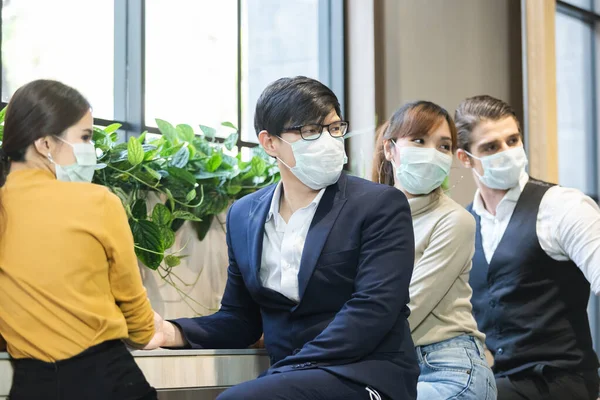 asian business people with wearing hygienic mask prophylactic manager talking in meeting work room planning.