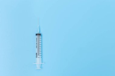 Mavi arkaplanda kopyalama alanı olan şırınga.