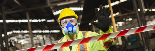Man engineer wearing safety uniform with gloves and gas mask show hand signal stop in dangerous area, don't enter. banner layout.