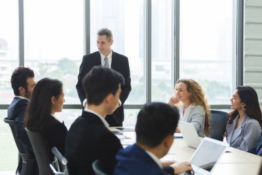 İş adamlarından oluşan bir grup toplantı odasında oturup eleştirenler, liderlik mevcut, iş ortaklığı konsepti.