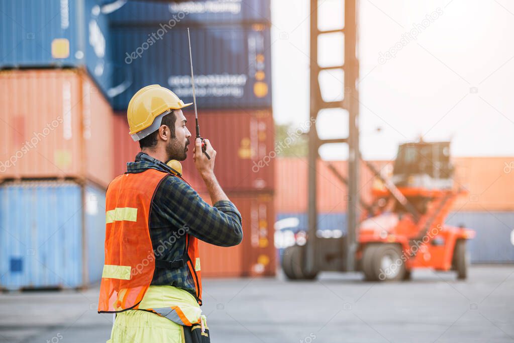 Foreman using radio communication control loading containers in shipping yard, for logistics and import export company. business logistics concept.