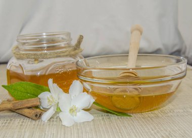 Ahşap arka planda bal ve beyaz çiçekler