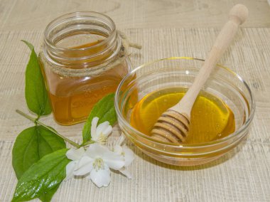 Ahşap arka planda bal ve beyaz çiçekler