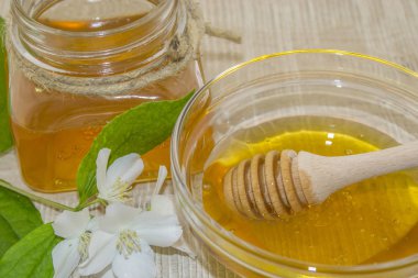 Ahşap arka planda bal ve beyaz çiçekler