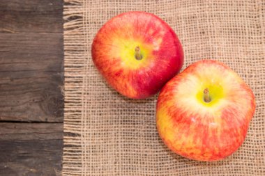 Ahşap bir masa üzerinde rustik bir arka plan ve beyaz bir arka plan üzerinde lezzetli, sulu, olgun, Kırmızı elma.