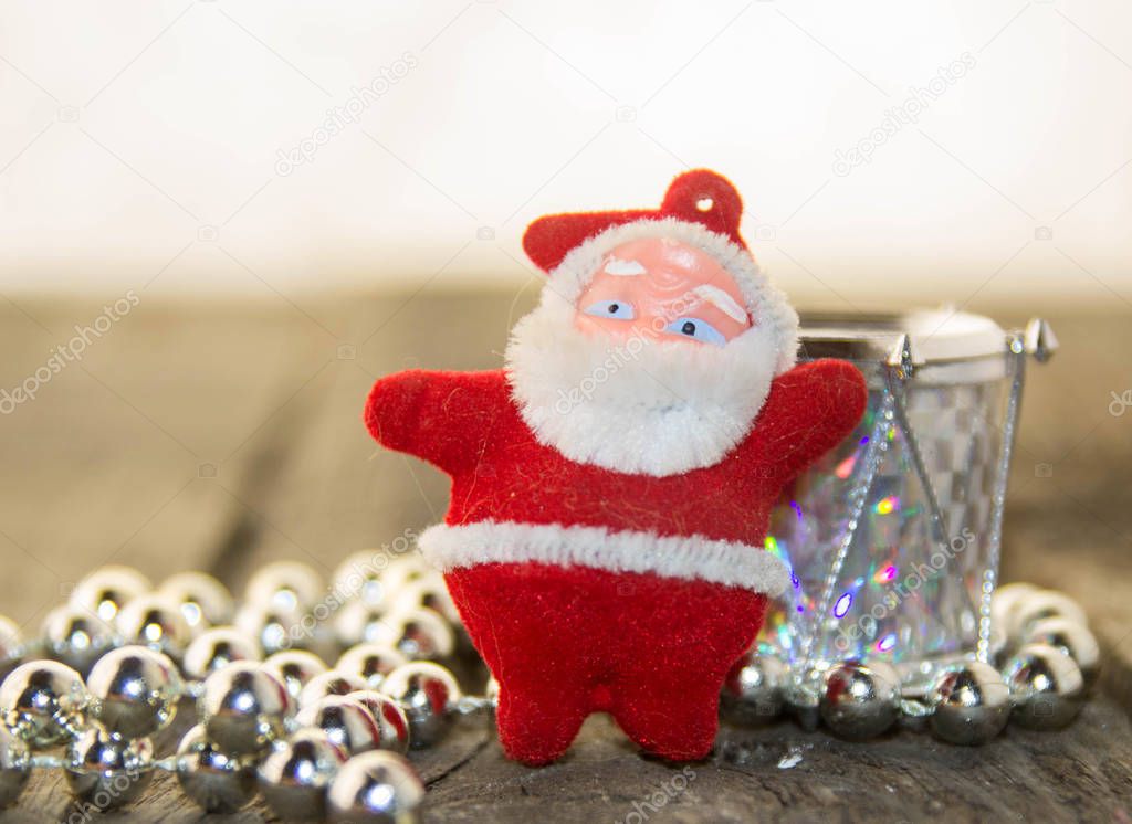 Christmas decoration with silver beads, silver shiny drum and Santa Claus on a wooden base