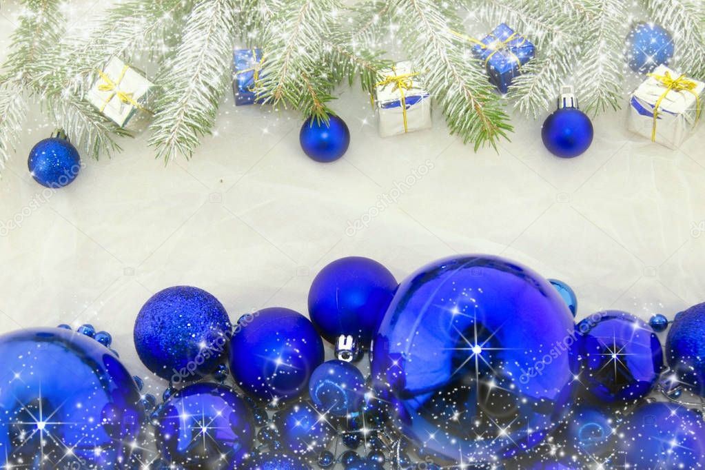Christmas decoration with shiny blue balls, packets and green branches of Christmas tree on a white background