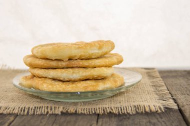 Kızarmış, kıtır, lezzetli hamur beyaz bir arka plan ile rustik ahşap bir masa üzerinde bir plaka üzerinde