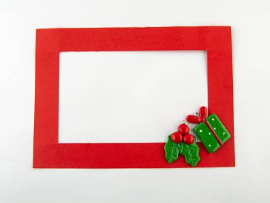 Noel 'deyiz! Beyaz arka planda kırmızı çerçeve ve tatil süslemeleri. Üst görünüm.