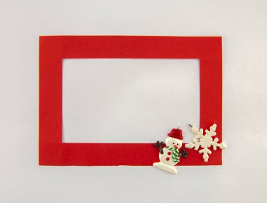 Noel 'deyiz! Beyaz arka planda kırmızı çerçeve ve tatil süslemeleri. Üst görünüm.