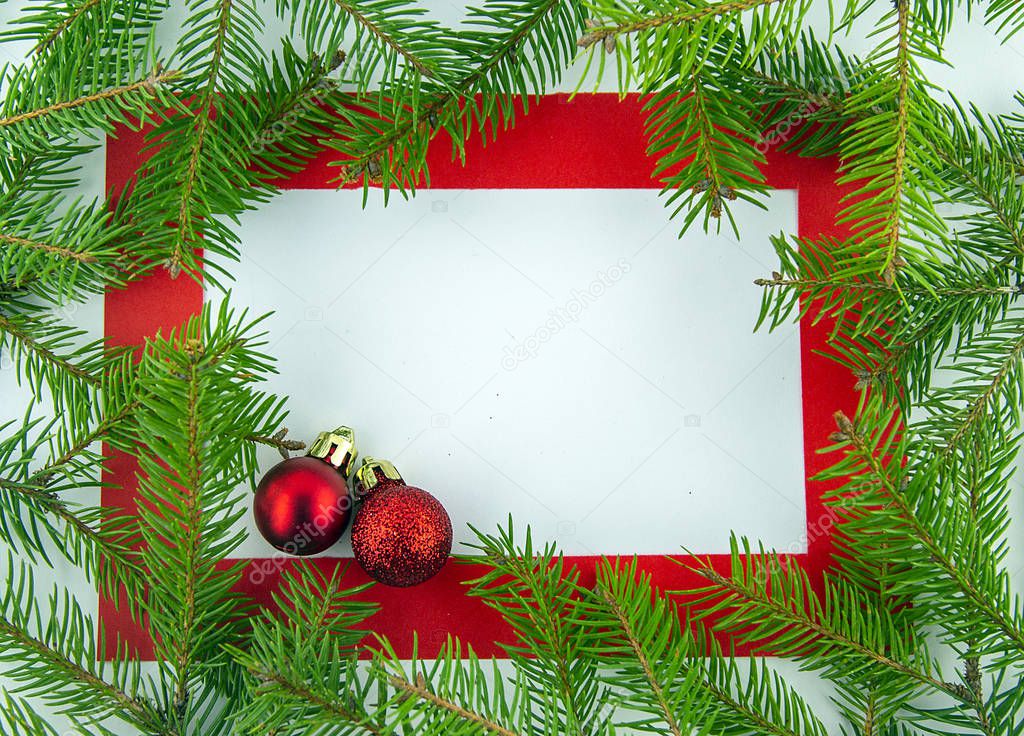 It's Christmas time! Red frame on white background with holiday decorations and branches of Christmas tree.