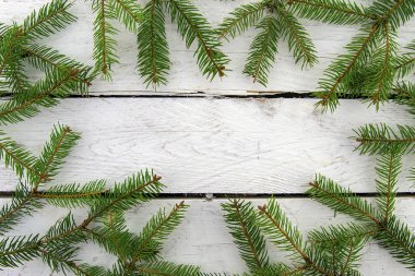 Beyaz ahşap bir arka planda Noel ağacının izole dalları. Üst görünüm.