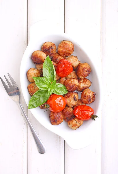 Köttbullar med tomater på vit platta — Stockfoto