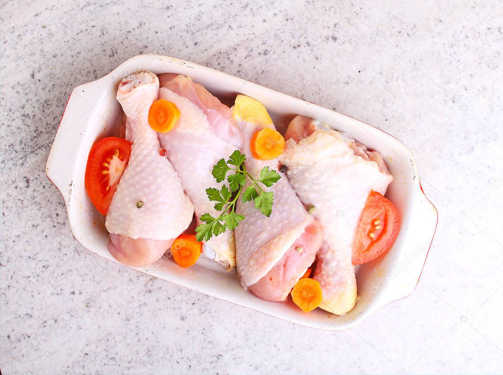 Raw chicken legs in baking dish