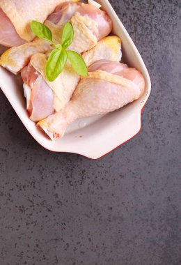 kırmızı bir tabak içinde çiğ tavuk budu.