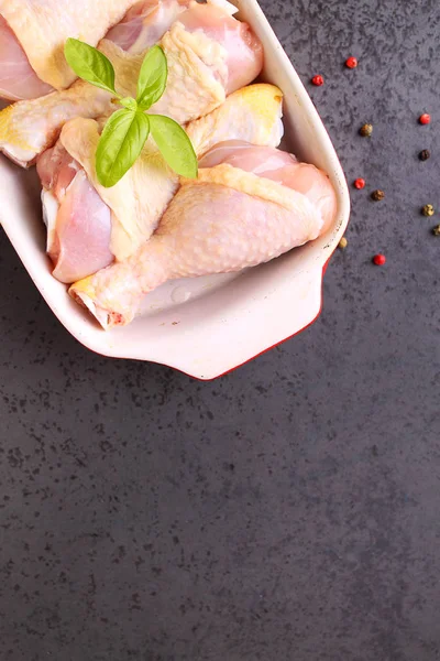 kırmızı bir tabak içinde çiğ tavuk budu.