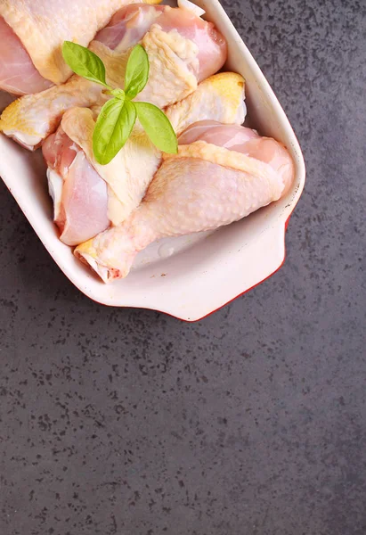 Patas de pollo crudas en un plato rojo . — Foto de Stock