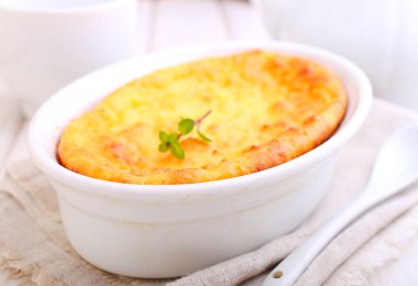 Süzme peynir güveç beyaz çanağı nane, Beyaz ahşap zemin üzerinde süslenmiş. Seçici odak.