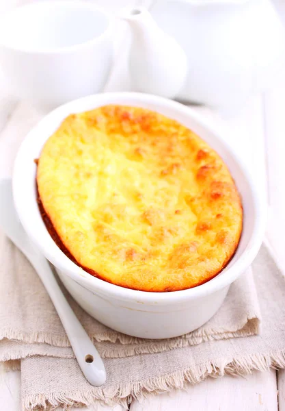 Cottage cheese casserole in white dish decorated with mint, on a white wooden background. Selective focus. — Stock Photo, Image