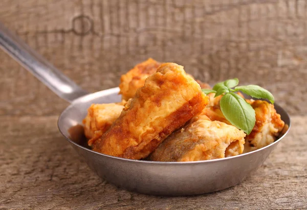 Fried fish hake in a frying pan decorated with basil — Stock Photo, Image